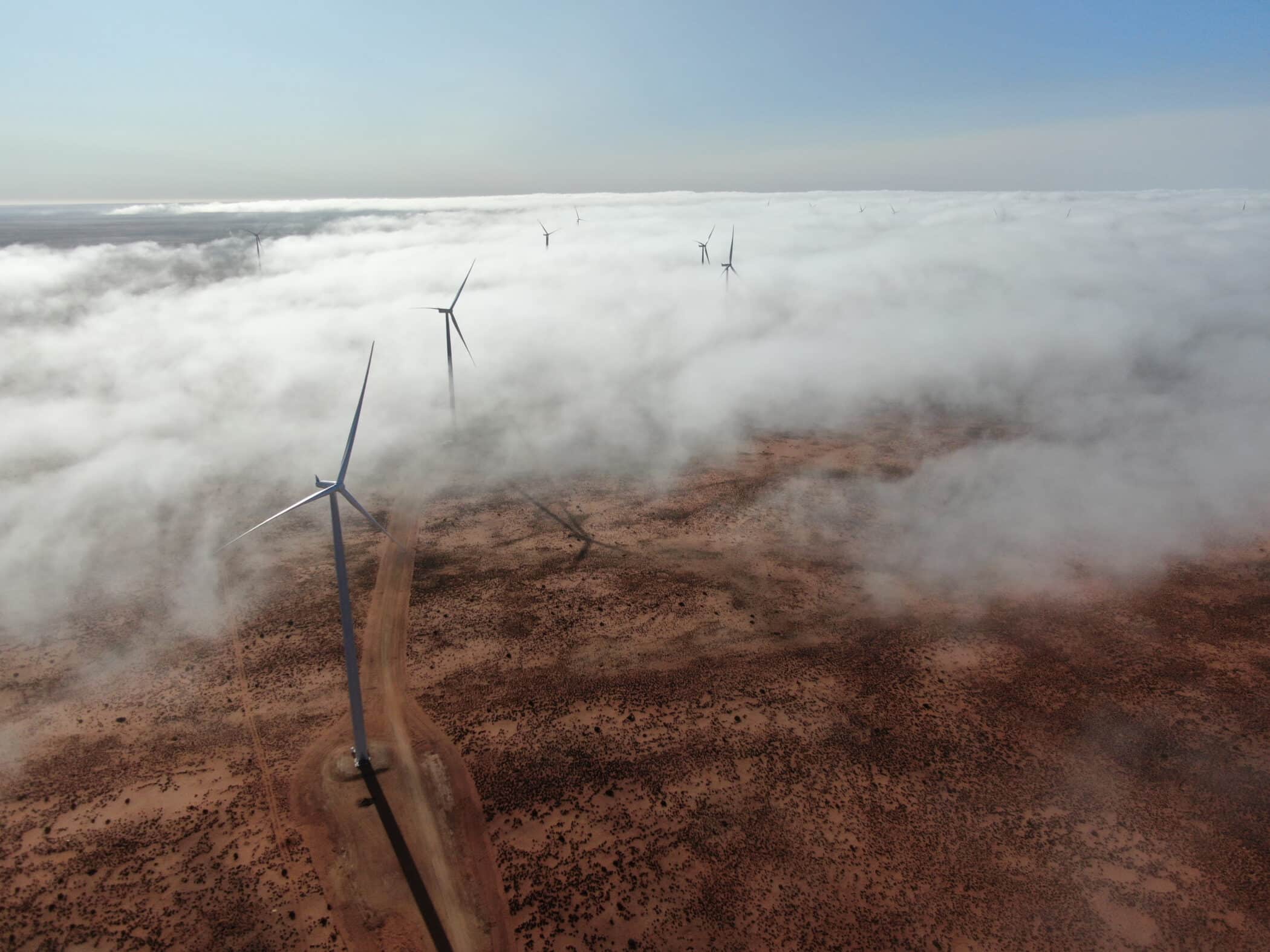 aerial drone shot of onshore wind turbines with hanging fog - mainstream renewable power onshore wind